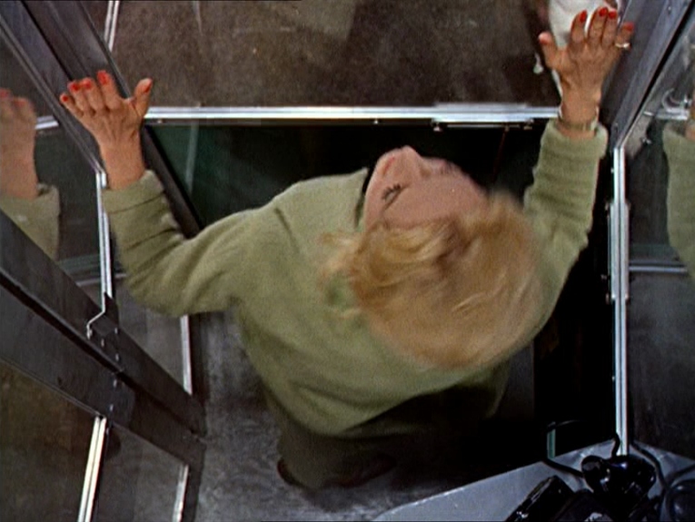 Melanie trapped in a phone booth, shot from above